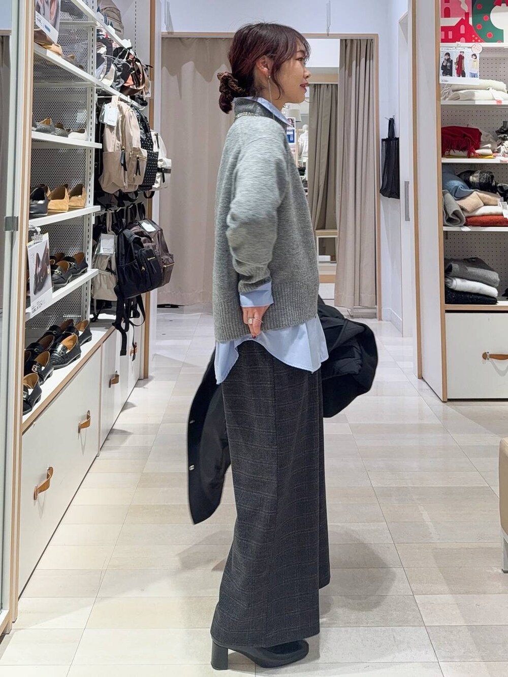 グリーン系のショルダーバッグ、ブラック系のステンカラーコート、ブルー系のシャツ/ブラウスを着用したレディースの冬コーディネートの5枚目の写真