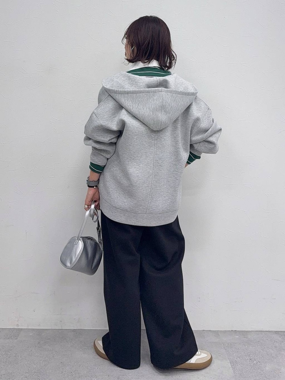 ホワイト系のスニーカー、グレー系のパーカー、ブラック系のスウェットパンツを着用したレディースの冬コーディネートの6枚目の写真