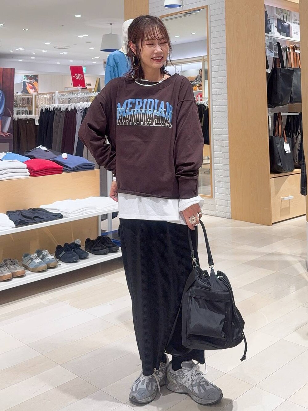 ブラック系のバックパック/リュック、ブラック系のスニーカー、グレー系のスカートを着用したレディースの秋コーディネートの4枚目の写真