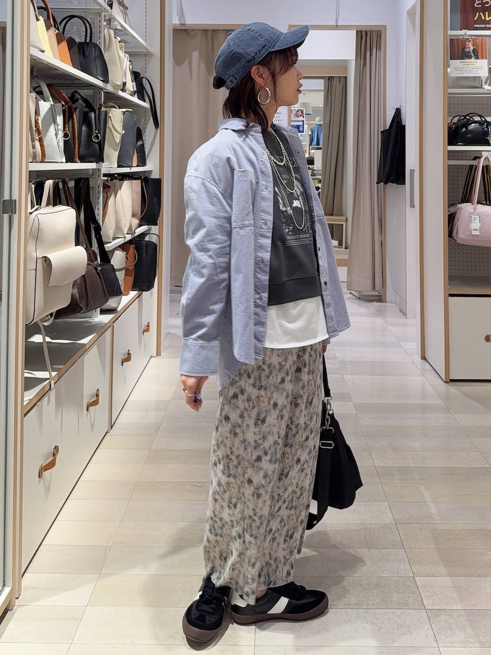 ブラック系のスニーカー、ブラック系のショルダーバッグ、ホワイト系のTシャツ/カットソーを着用したレディースの春コーディネートの5枚目の写真