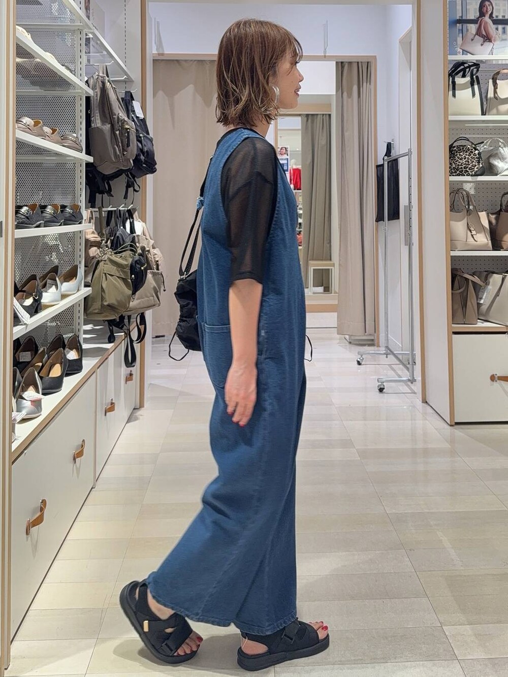 ブルー系のサロペット/オーバーオール、ブラック系のタンクトップ、ブラック系のショルダーバッグを着用したレディースの夏コーディネートの6枚目の写真