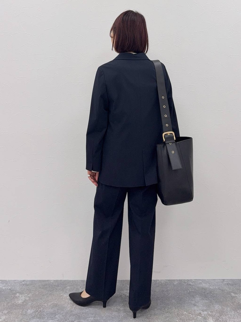 ブラック系のショルダーバッグ、ブルー系のスラックス、ホワイト系のシャツ/ブラウスを着用したレディースの秋コーディネートの4枚目の写真