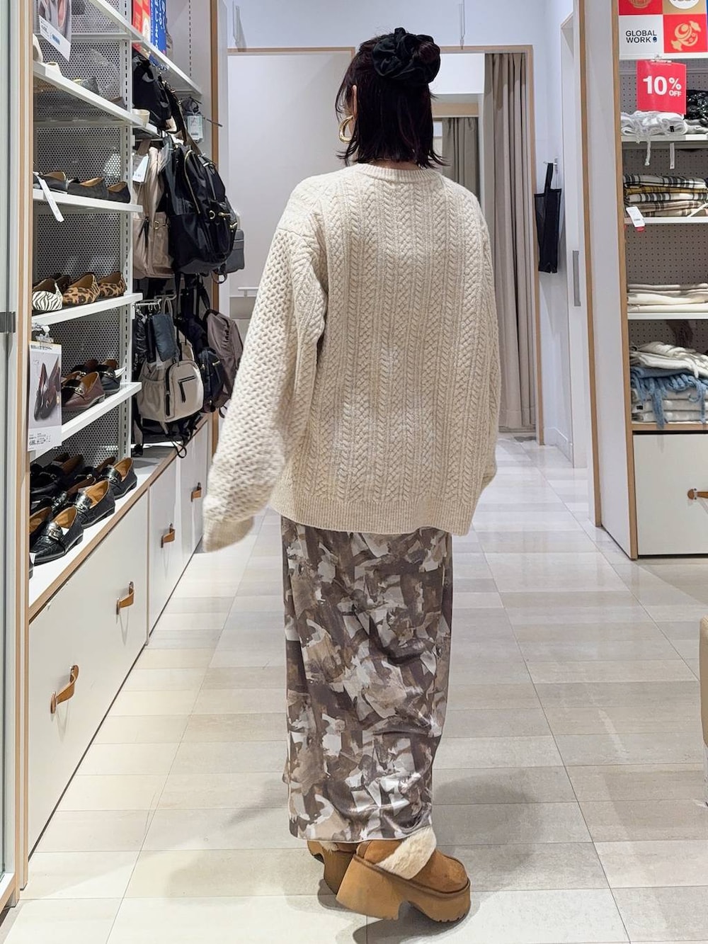 ブラック系のその他アウター、イエロー系のブーツ、ホワイト系のニット/セーターを着用したレディースの冬コーディネートの8枚目の写真