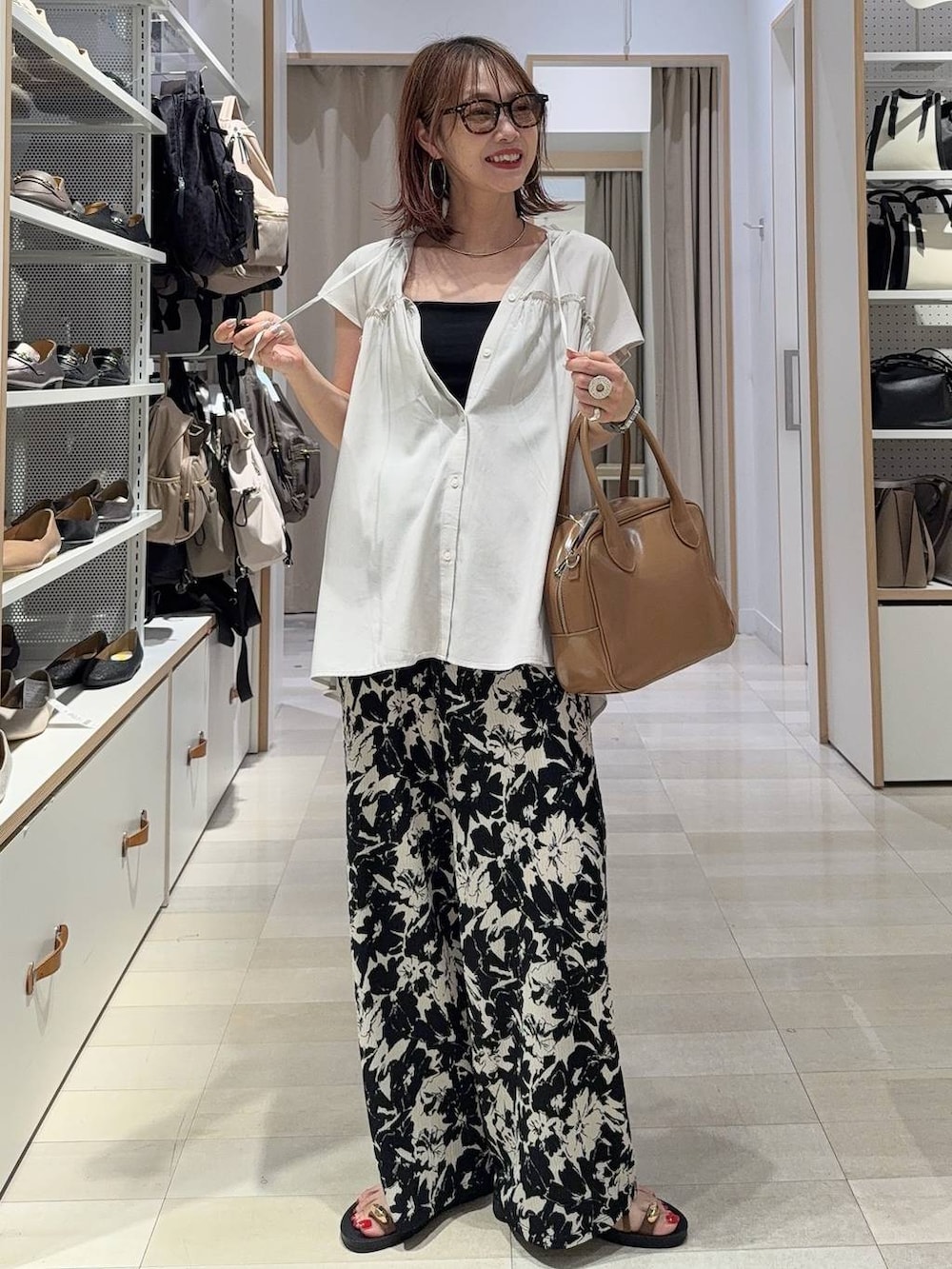 ブルー系のデニムパンツ、ブラック系のショルダーバッグ、ブラック系のサンダルを着用したレディースの夏コーディネートの2枚目の写真