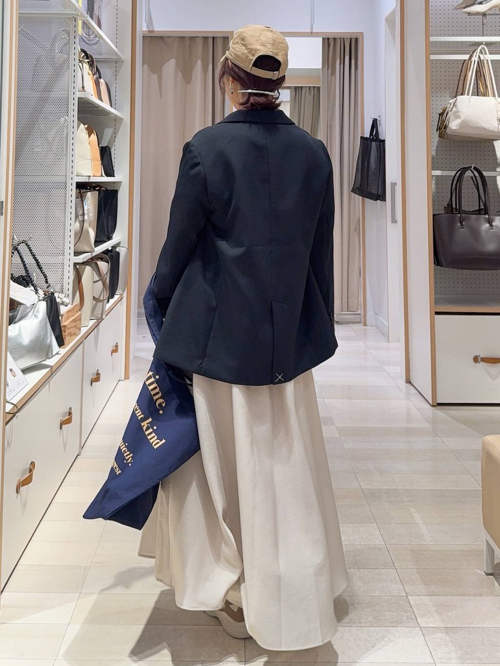 ベージュ系のスカート、ブラウン系のその他シューズ、ブルー系のトートバッグを着用したレディースの冬コーディネートの7枚目の写真