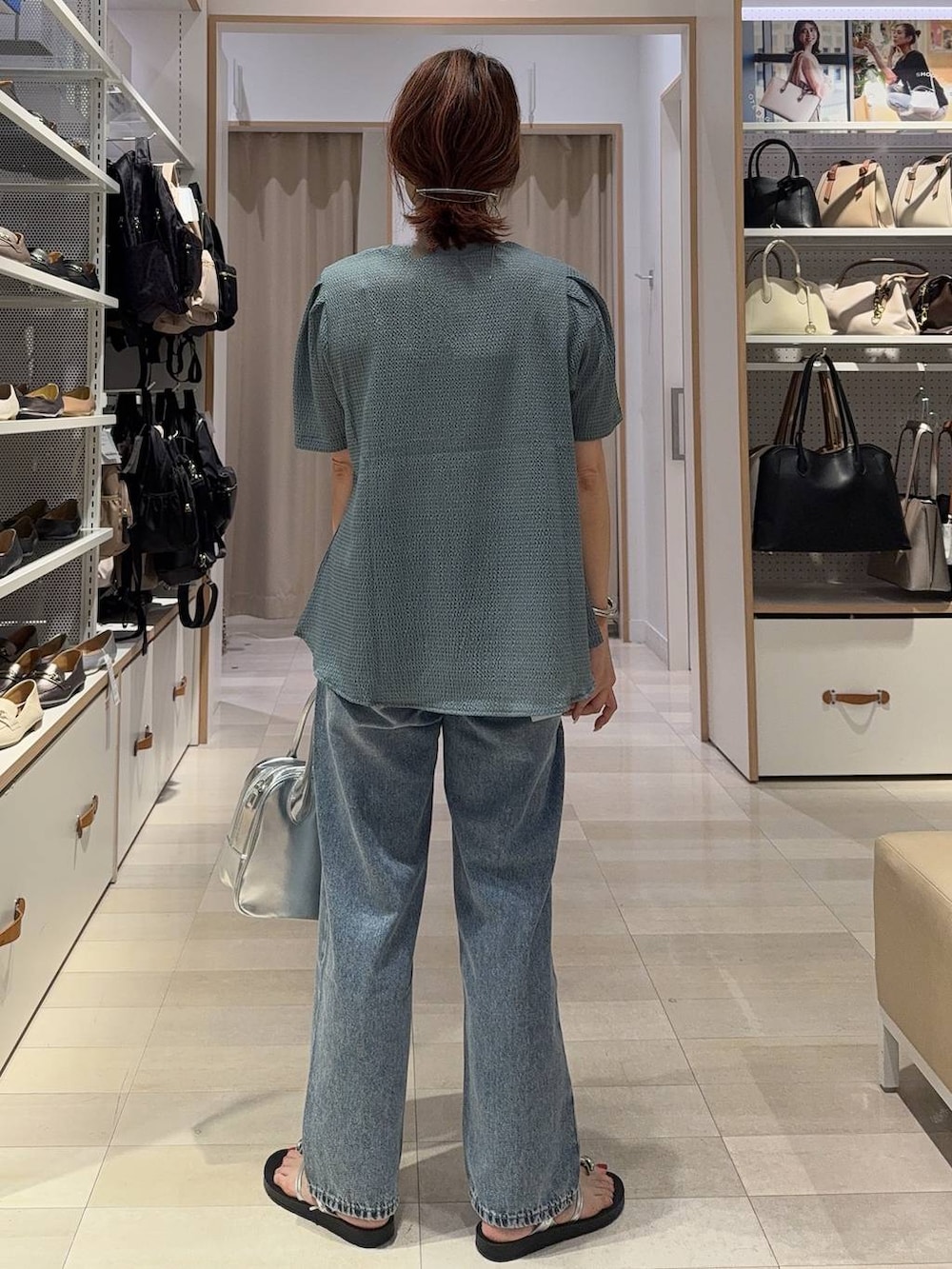 ブルー系のデニムパンツ、グレー系のボストンバッグ、ブラック系のカーディガン/ボレロを着用したレディースの夏コーディネートの9枚目の写真