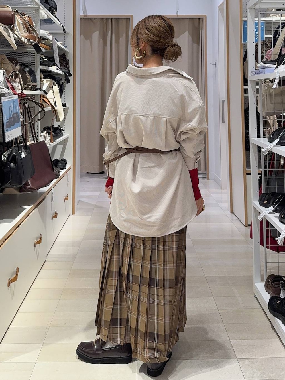 レッド系のTシャツ/カットソー、ブラウン系のボディバッグ/ウエストポーチ、ブラウン系のローファーを着用したレディースの秋コーディネートの4枚目の写真