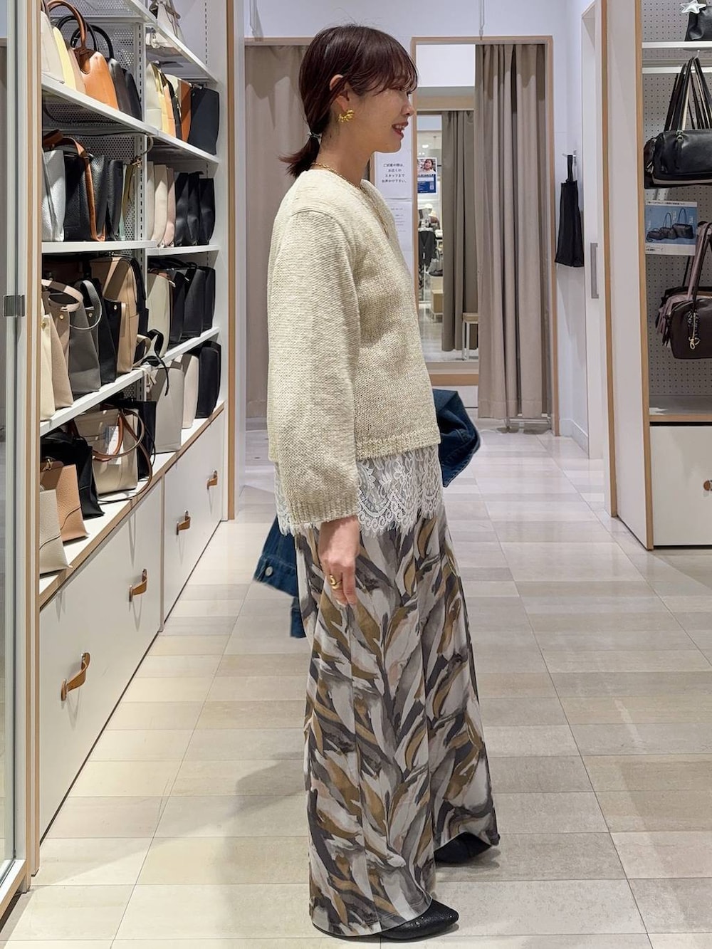 ブラック系のパンプス、ベージュ系のトートバッグ、ブルー系のデニムジャケットを着用したレディースの春コーディネートの5枚目の写真