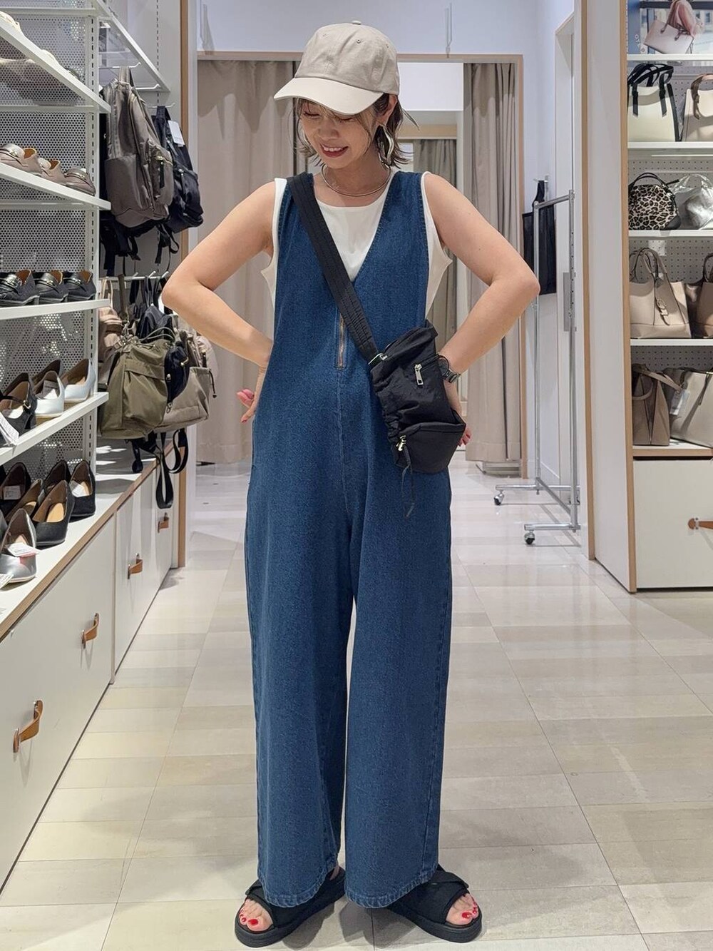 ブラック系のサンダル、ブラック系のショルダーバッグ、シルバー系のネックレスを着用したレディースの春コーディネートの4枚目の写真