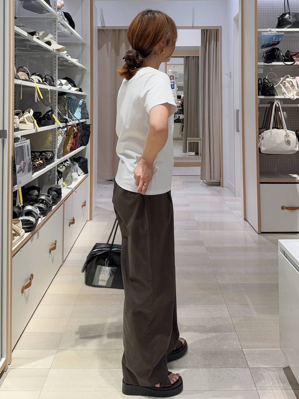 ブラック系のボストンバッグ、ブラウン系のその他パンツ、ホワイト系のTシャツ/カットソーを着用したレディースの夏コーディネートの6枚目の写真