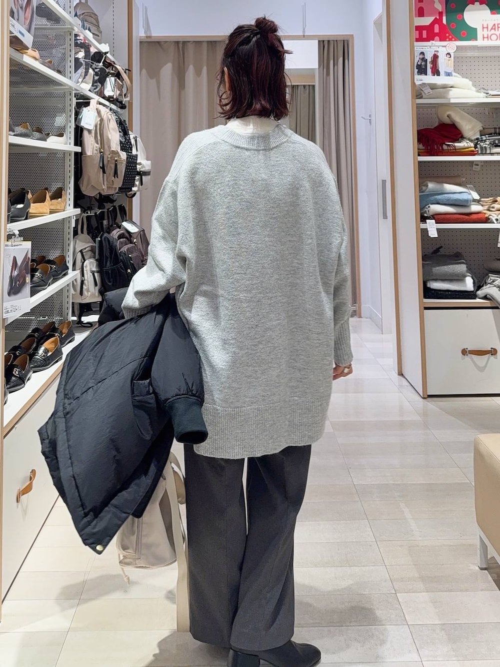 ホワイト系のショルダーバッグ、ブラック系のダウンジャケット/コート、ホワイト系のニット/セーターを着用したレディースの冬コーディネートの7枚目の写真