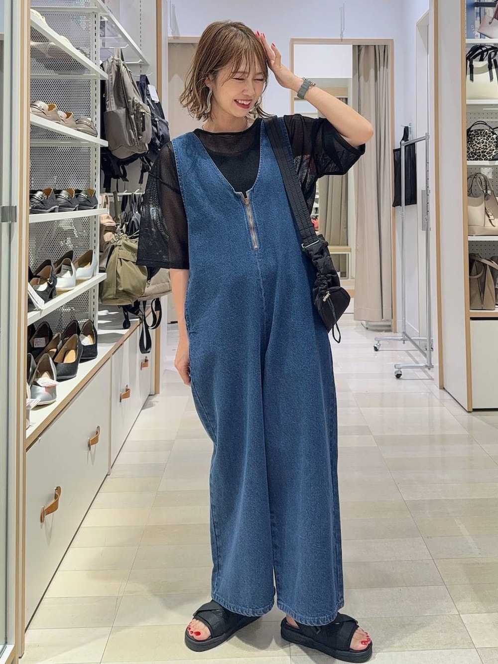 ブルー系のサロペット/オーバーオール、ピンク系のシャツ/ブラウス、ブラック系のショルダーバッグを着用したレディースの春コーディネートの3枚目の写真