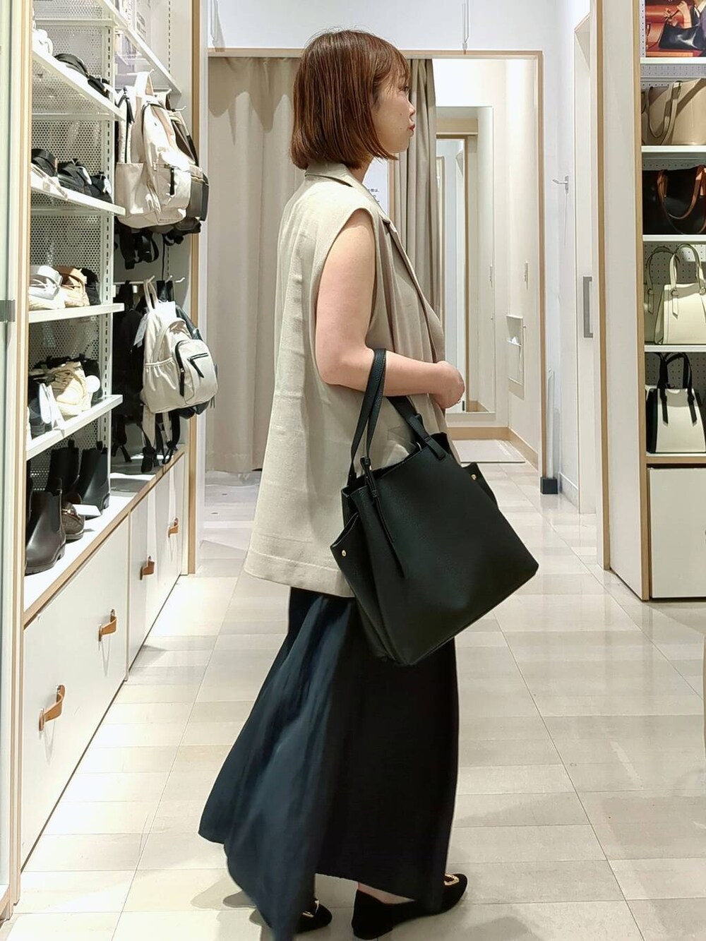 ブルー系のその他パンツ、ベージュ系のベスト、ブラック系のショルダーバッグを着用したレディースの春コーディネートの6枚目の写真