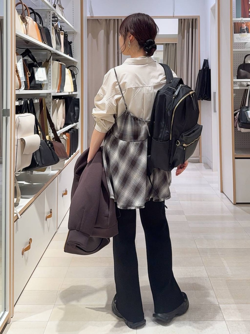 ベージュ系のシャツ/ブラウス、ブラック系のスニーカー、ブラック系のバックパック/リュックを着用したレディースの春コーディネートの6枚目の写真