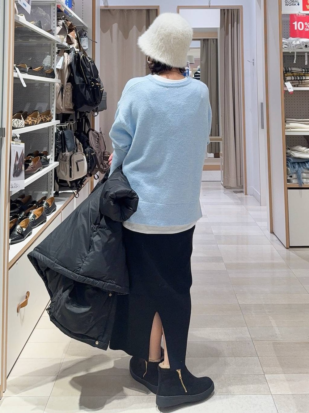 ブラック系のショルダーバッグ、ブラック系のダウンジャケット/コート、ブルー系のニット/セーターを着用したレディースの冬コーディネートの7枚目の写真