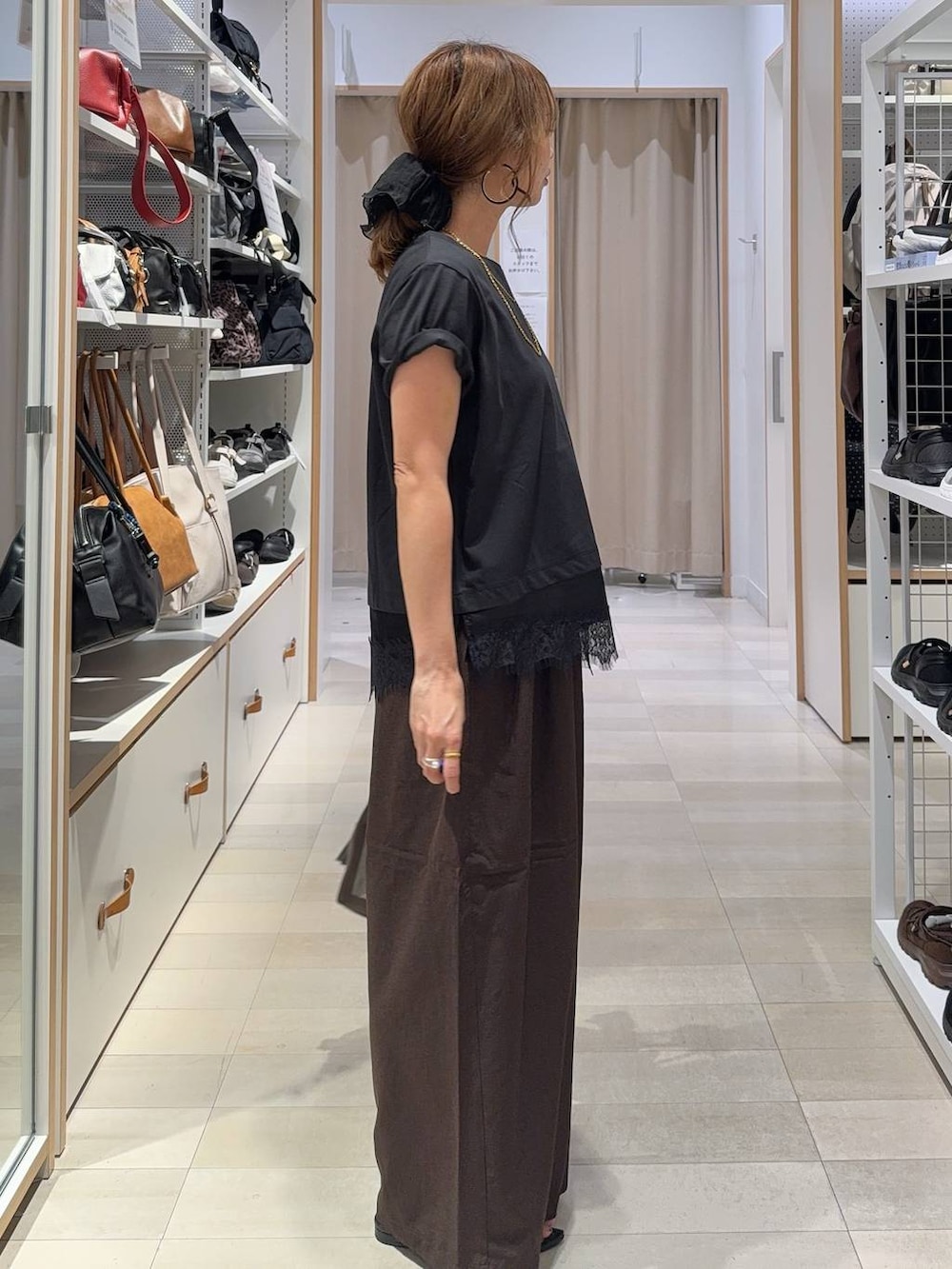 ブラウン系のボストンバッグ、ブラウン系のその他パンツ、ブラック系のTシャツ/カットソーを着用したレディースの夏コーディネートの4枚目の写真
