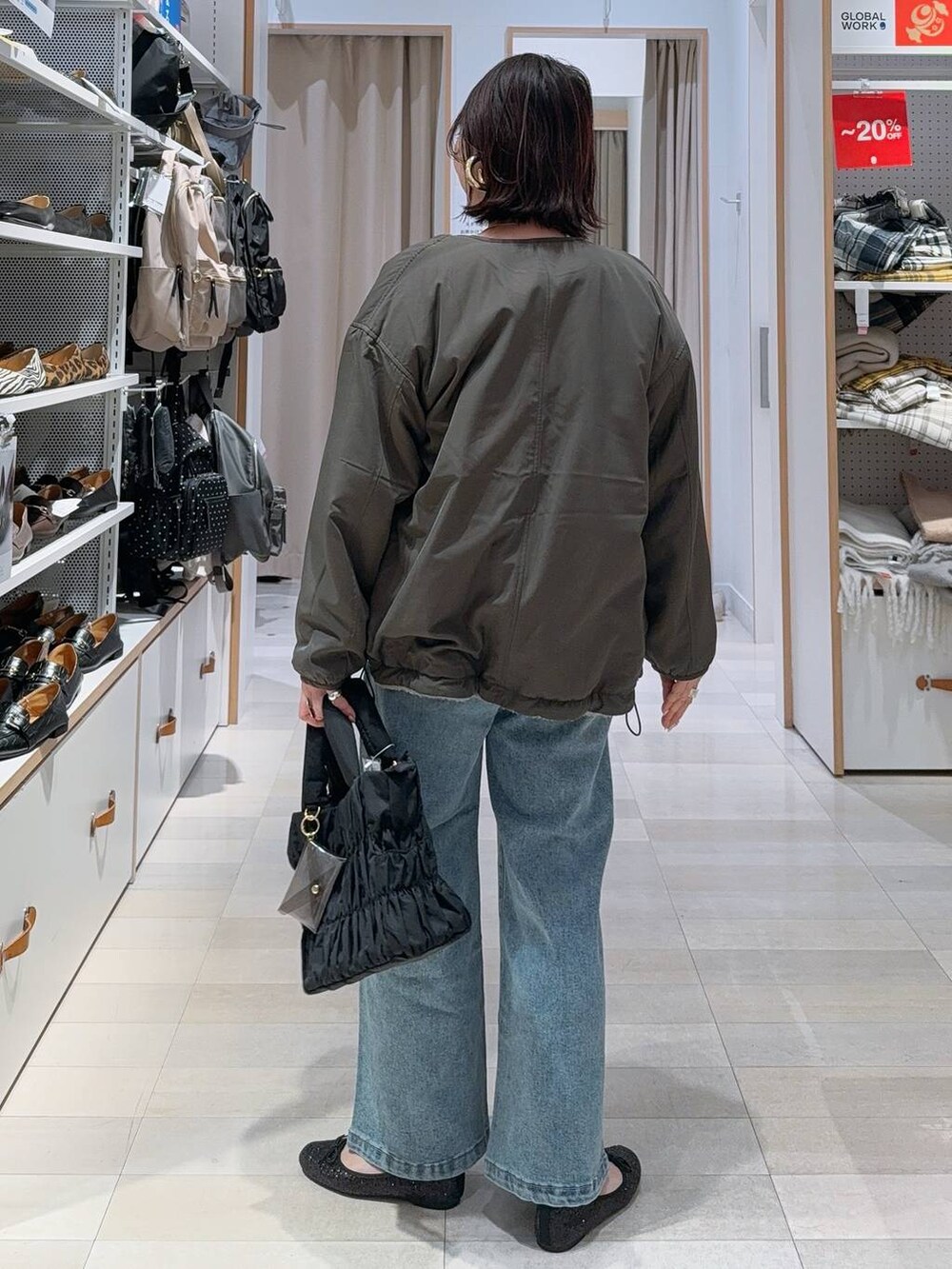 ブラック系のバレエシューズ、グレー系のブルゾン、ブルー系のデニムパンツを着用したレディースの冬コーディネートの6枚目の写真