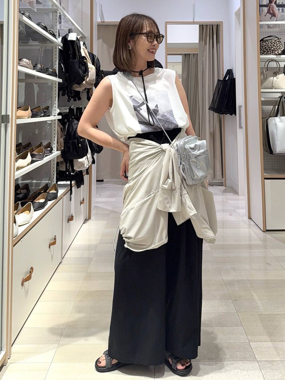 シルバー系のショルダーバッグ、グレー系のサンダル、ブラック系のその他パンツを着用したレディースの夏コーディネートの2枚目の写真