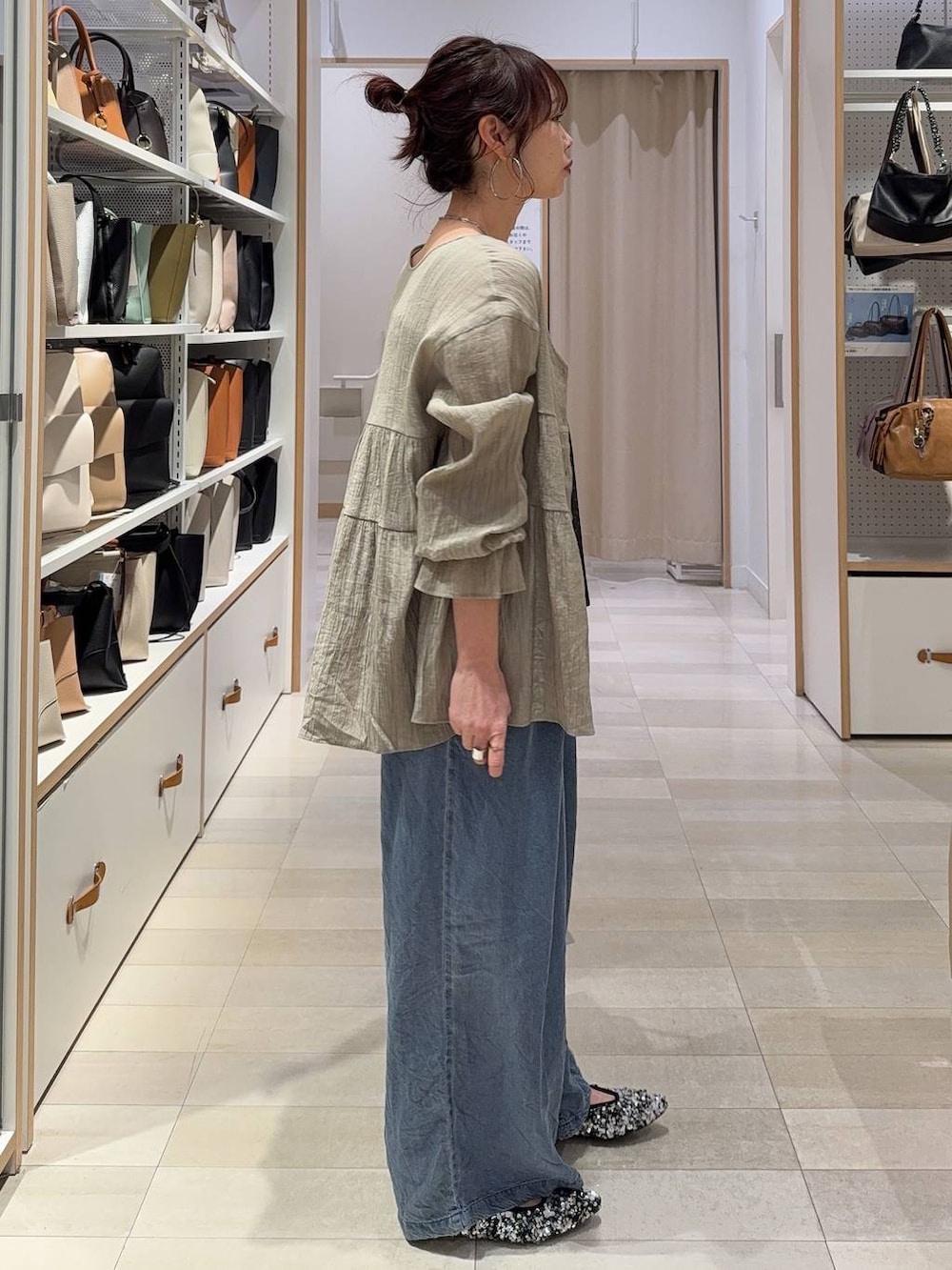 ホワイト系のブルゾン、ブルー系のデニムパンツを着用したレディースの春コーディネートの4枚目の写真