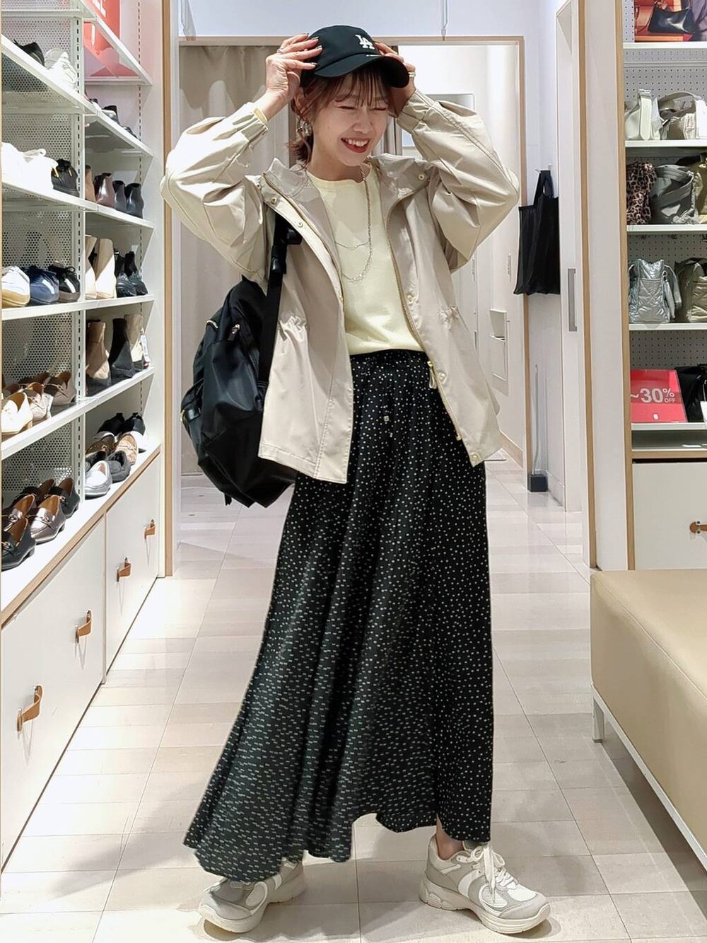 ブラック系のその他パンツ、ブラック系のバックパック/リュック、ベージュ系のマウンテンパーカーを着用したレディースの春コーディネートの2枚目の写真