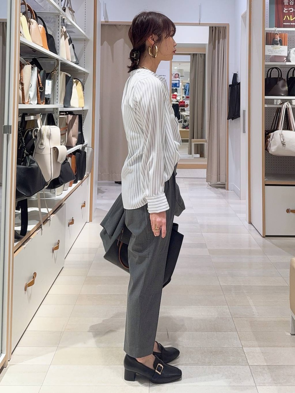 ブラック系のローファー、グレー系のスラックス、ブラック系のトートバッグを着用したレディースの冬コーディネートの8枚目の写真