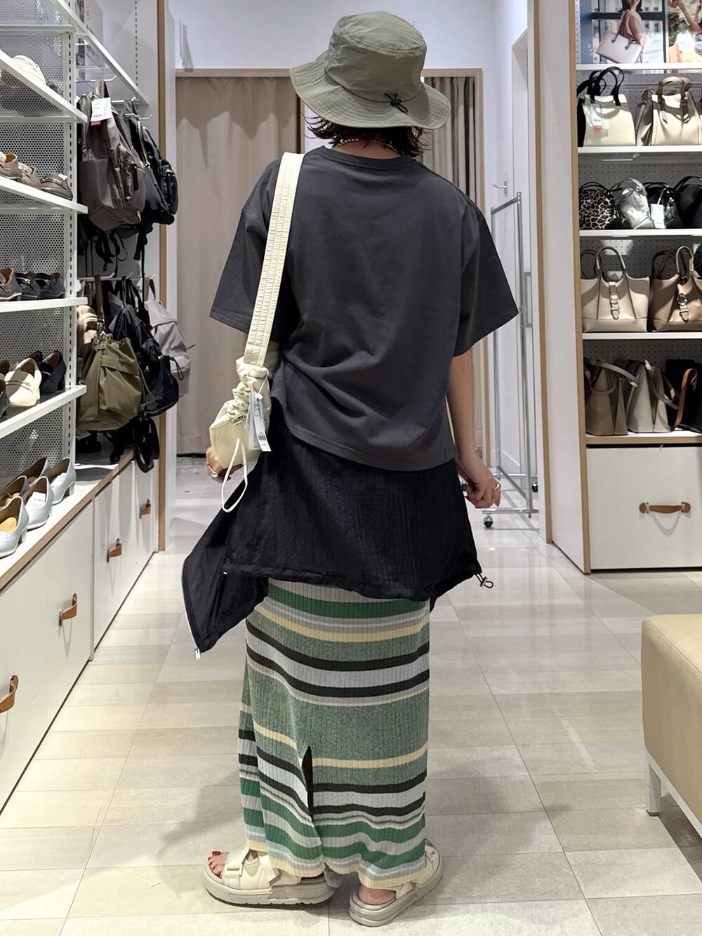 ブラック系のTシャツ/カットソー、ブラック系のブルゾン、グリーン系のスカートを着用したレディースの春コーディネートの4枚目の写真