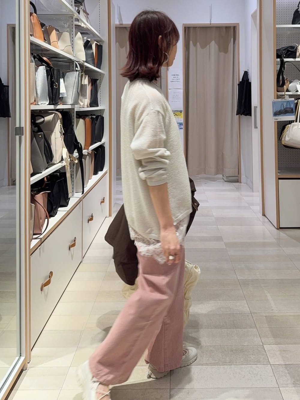 ベージュ系のトートバッグ、ブラウン系のパーカー、ピンク系のデニムパンツを着用したレディースの春コーディネートの6枚目の写真