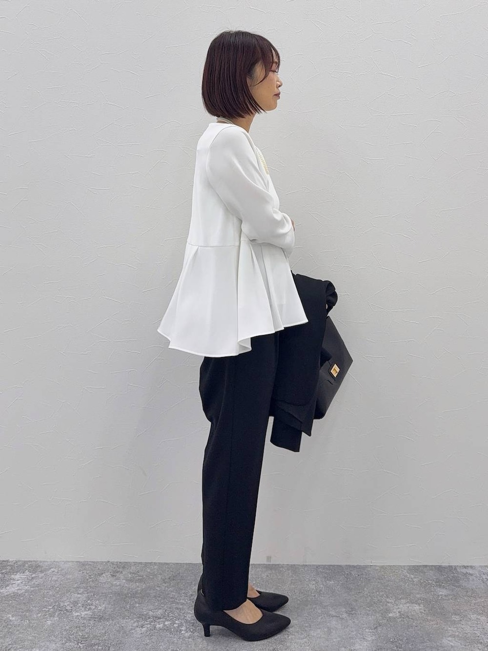 ブラック系のパンプス、ブラック系のセットアップ、その他のネックレスを着用したレディースの秋コーディネートの5枚目の写真