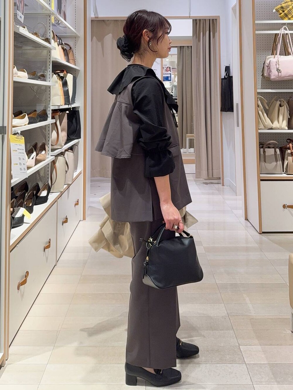 ブラック系のショルダーバッグ、ブラック系のローファー、グレー系のセットアップを着用したレディースの冬コーディネートの8枚目の写真