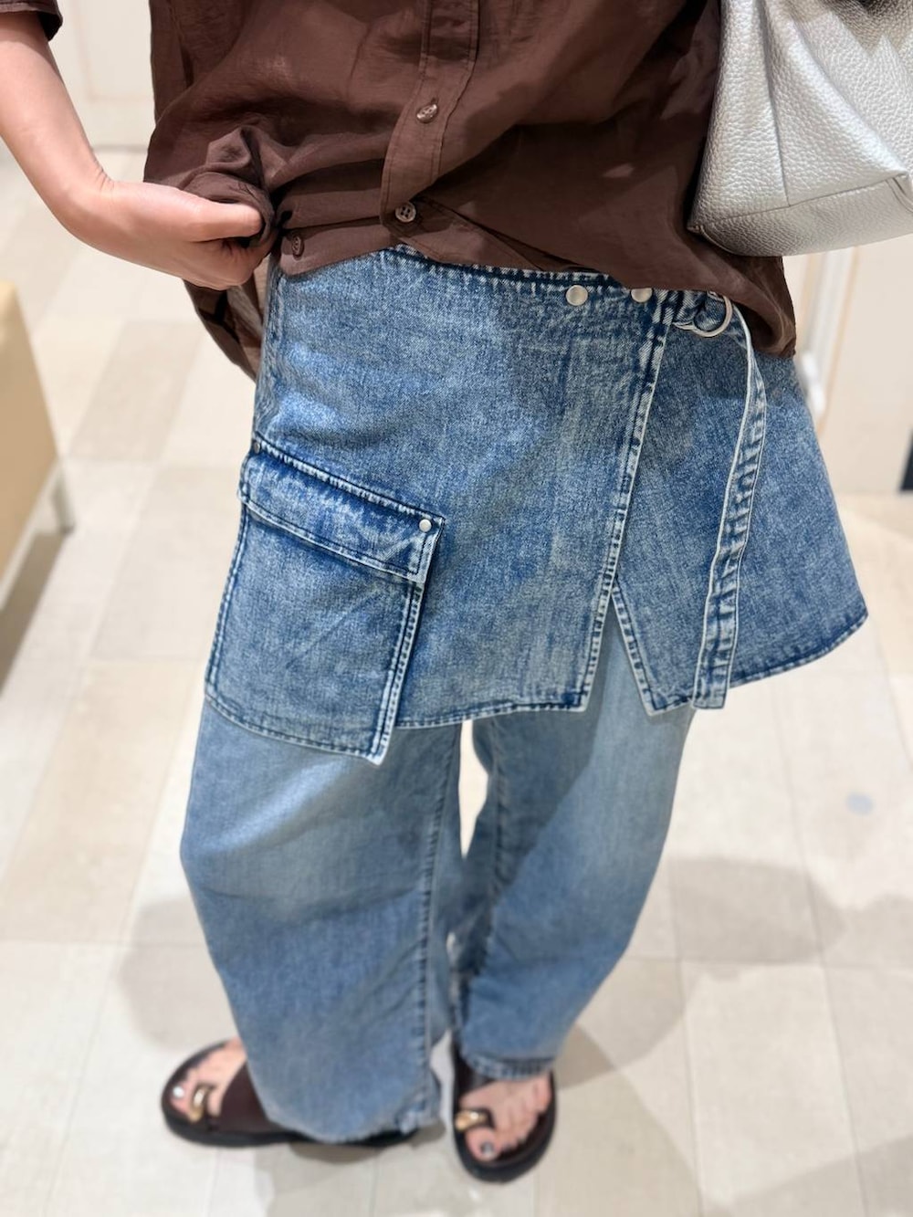 ホワイト系のタンクトップ、ブルー系のデニムパンツ、ブラウン系のシャツ/ブラウスを着用したレディースの夏コーディネートの3枚目の写真