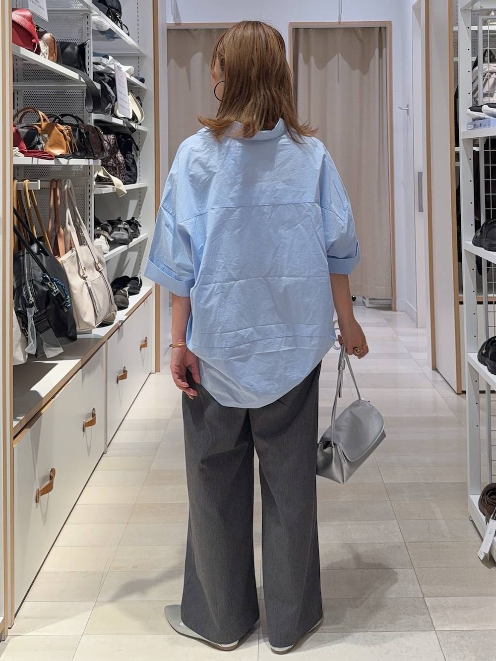 シルバー系のパンプス、シルバー系のショルダーバッグ、ブルー系のシャツ/ブラウスを着用したレディースの夏コーディネートの3枚目の写真