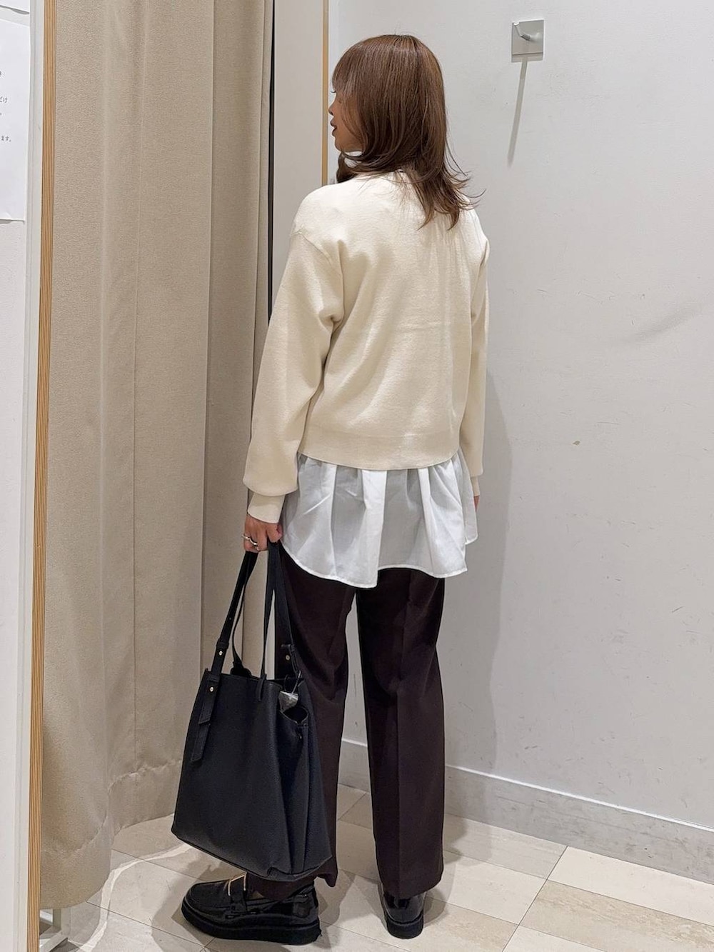 ブラック系のトートバッグ、ブラック系のローファー、ホワイト系のTシャツ/カットソーを着用したレディースの秋コーディネートの3枚目の写真