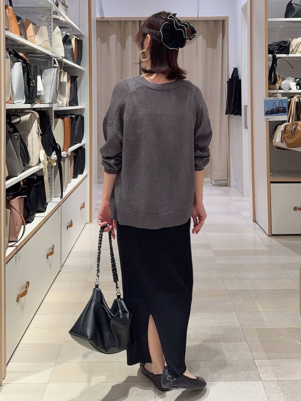 ブラック系のバレエシューズ、ブラック系のスカート、シルバー系のネックレスを着用したレディースの春コーディネートの4枚目の写真