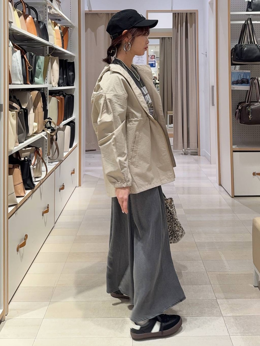 ブラック系のスニーカー、ベージュ系のパーカー、ブラウン系のトートバッグを着用したレディースの春コーディネートの4枚目の写真