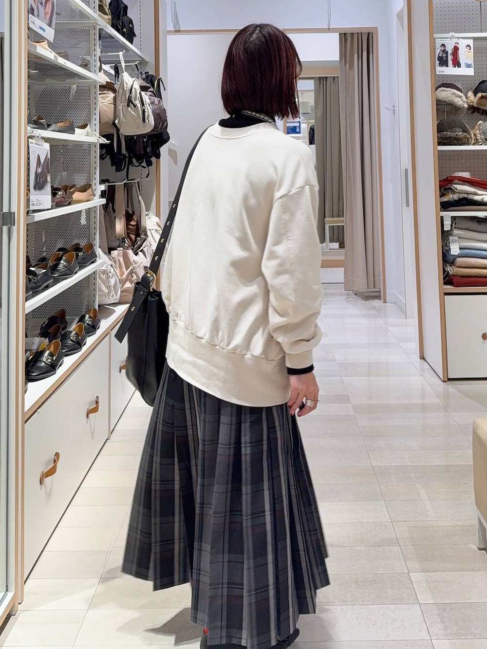 ブラック系のショルダーバッグ、ブラック系のニット/セーター、ブラック系のその他アウターを着用したレディースの秋コーディネートの8枚目の写真