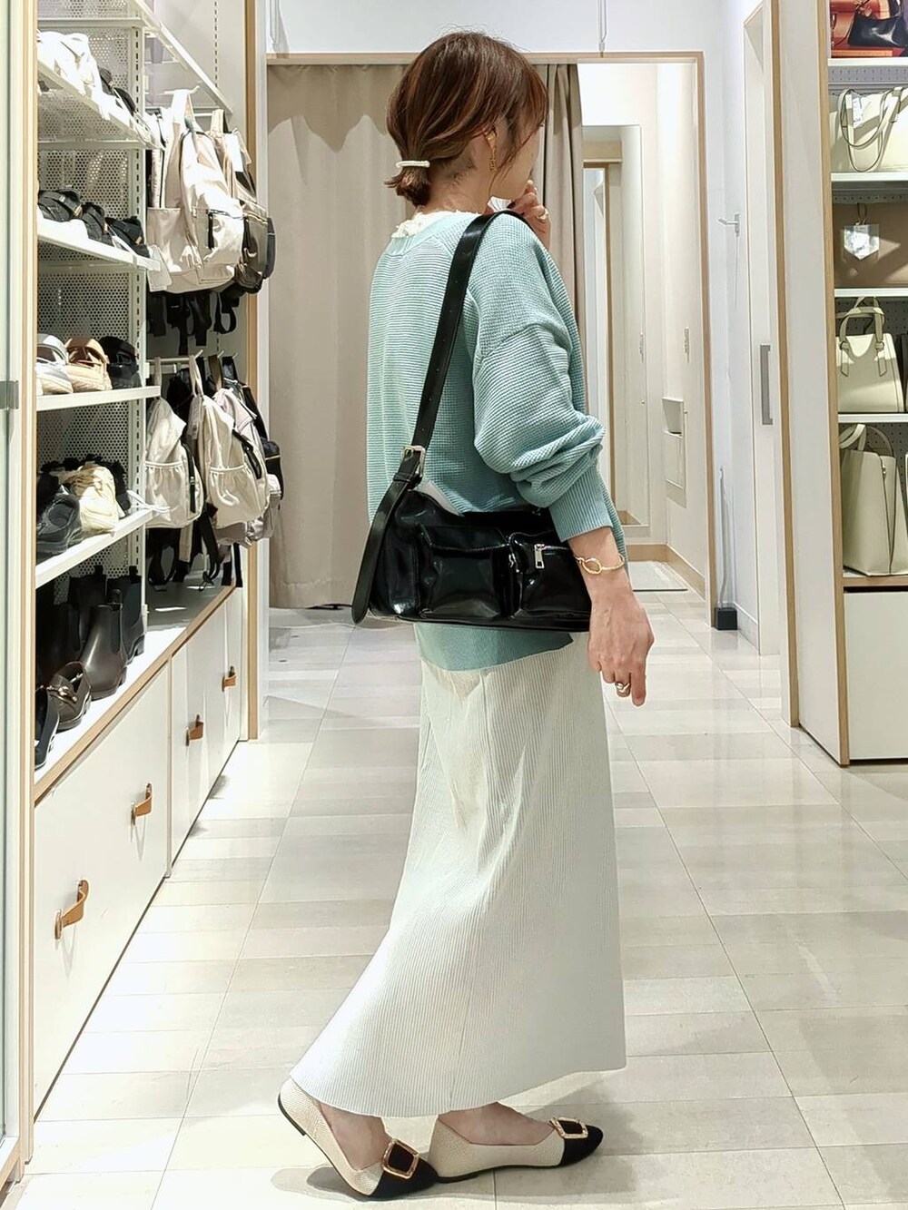 ブラック系のショルダーバッグ、グリーン系のカーディガン/ボレロ、グレー系のスカートを着用したレディースの春コーディネートの5枚目の写真