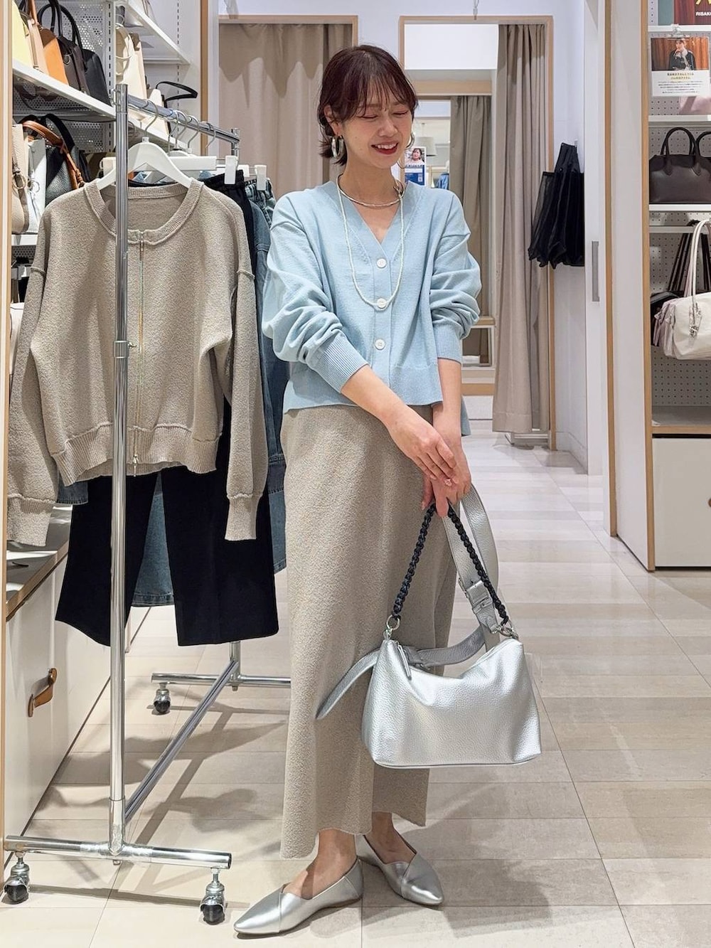 シルバー系のパンプス、ブラック系のキャミソール、ブルー系のデニムパンツを着用したレディースの冬コーディネートの4枚目の写真