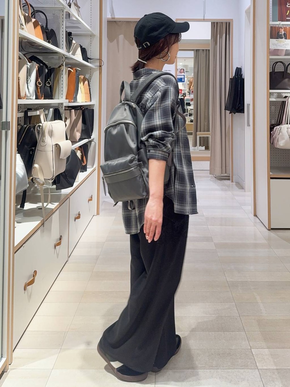 ブラック系のスニーカー、グレー系のバックパック/リュック、ブラック系のシャツ/ブラウスを着用したレディースの冬コーディネートの8枚目の写真