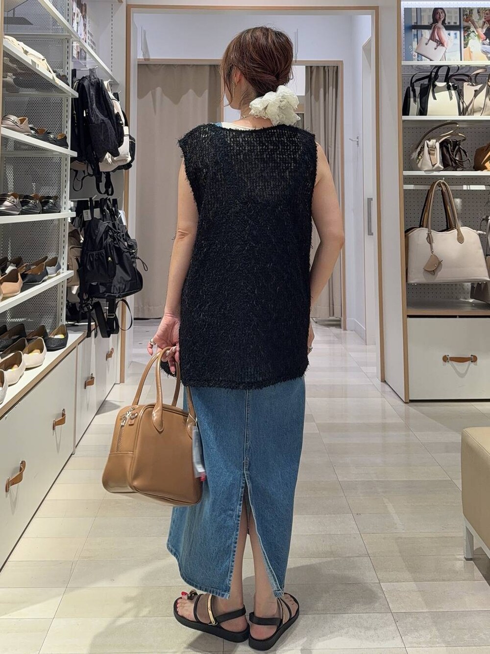 ブルー系のジャンパースカート、ベージュ系のボストンバッグ、ブラック系のサンダルを着用したレディースの夏コーディネートの4枚目の写真