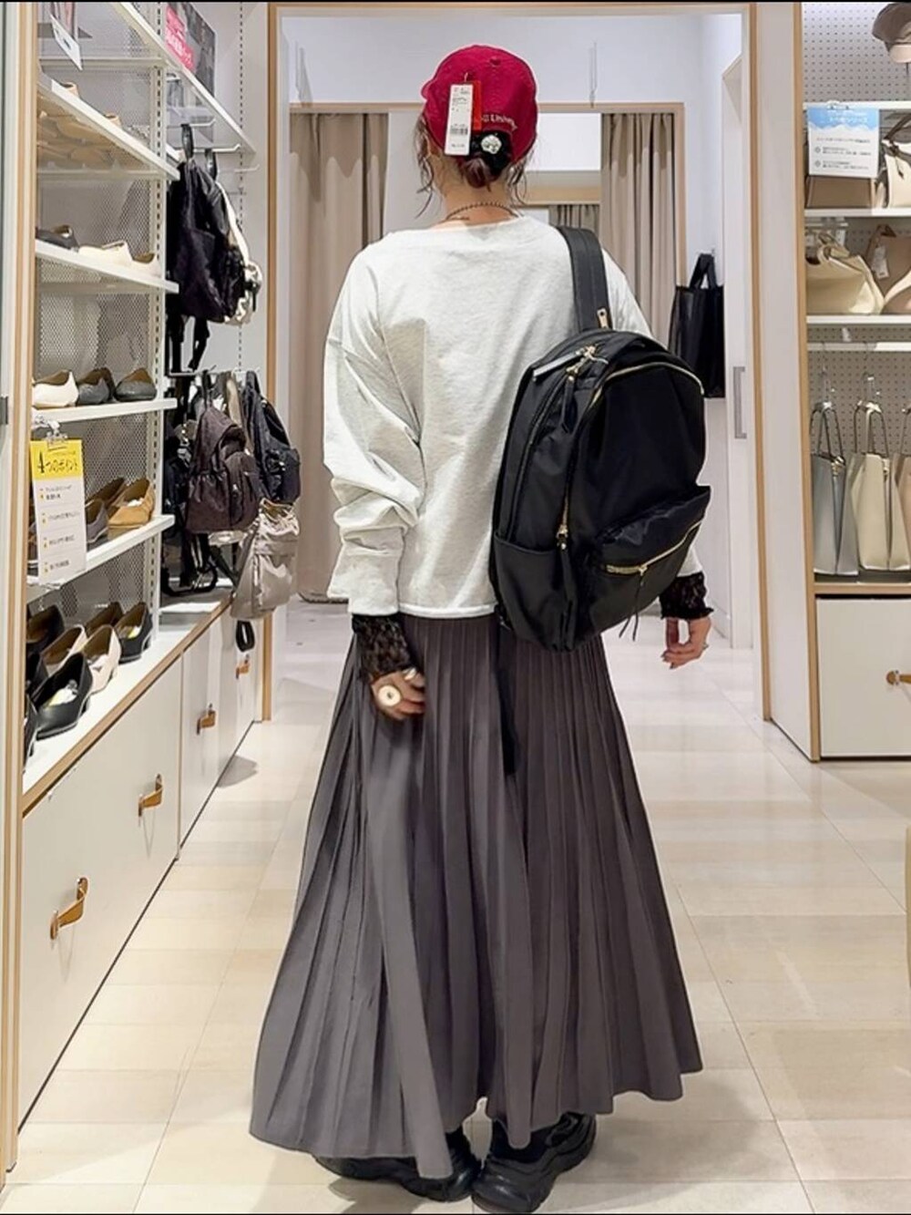 ブラック系のバックパック/リュック、ブラック系のスニーカー、グレー系のスカートを着用したレディースの秋コーディネートの7枚目の写真