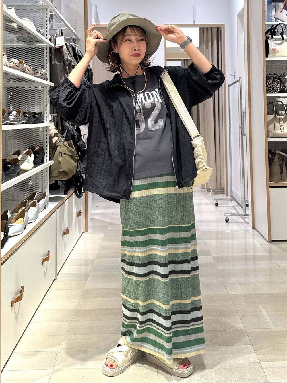 ブラック系のTシャツ/カットソー、ブラック系のブルゾン、グリーン系のスカートを着用したレディースの春コーディネートの2枚目の写真