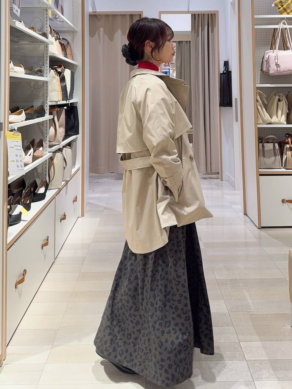 ブラック系のバレエシューズ、レッド系のニット/セーター、ベージュ系のトレンチコートを着用したレディースの冬コーディネートの4枚目の写真