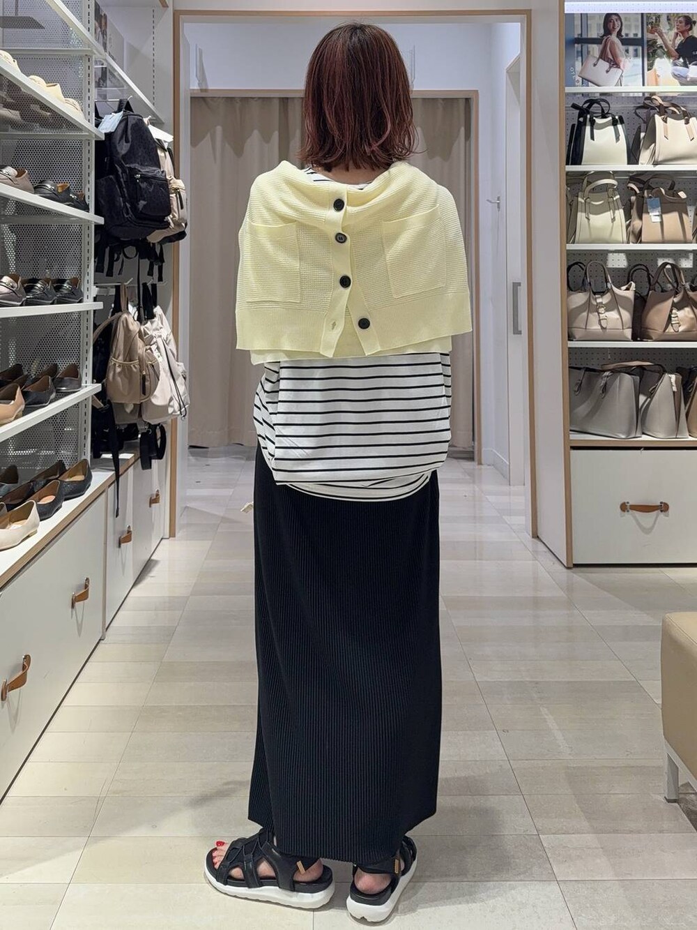 ブラック系のスカート、イエロー系のカーディガン/ボレロ、ホワイト系のトートバッグを着用したレディースの夏コーディネートの5枚目の写真