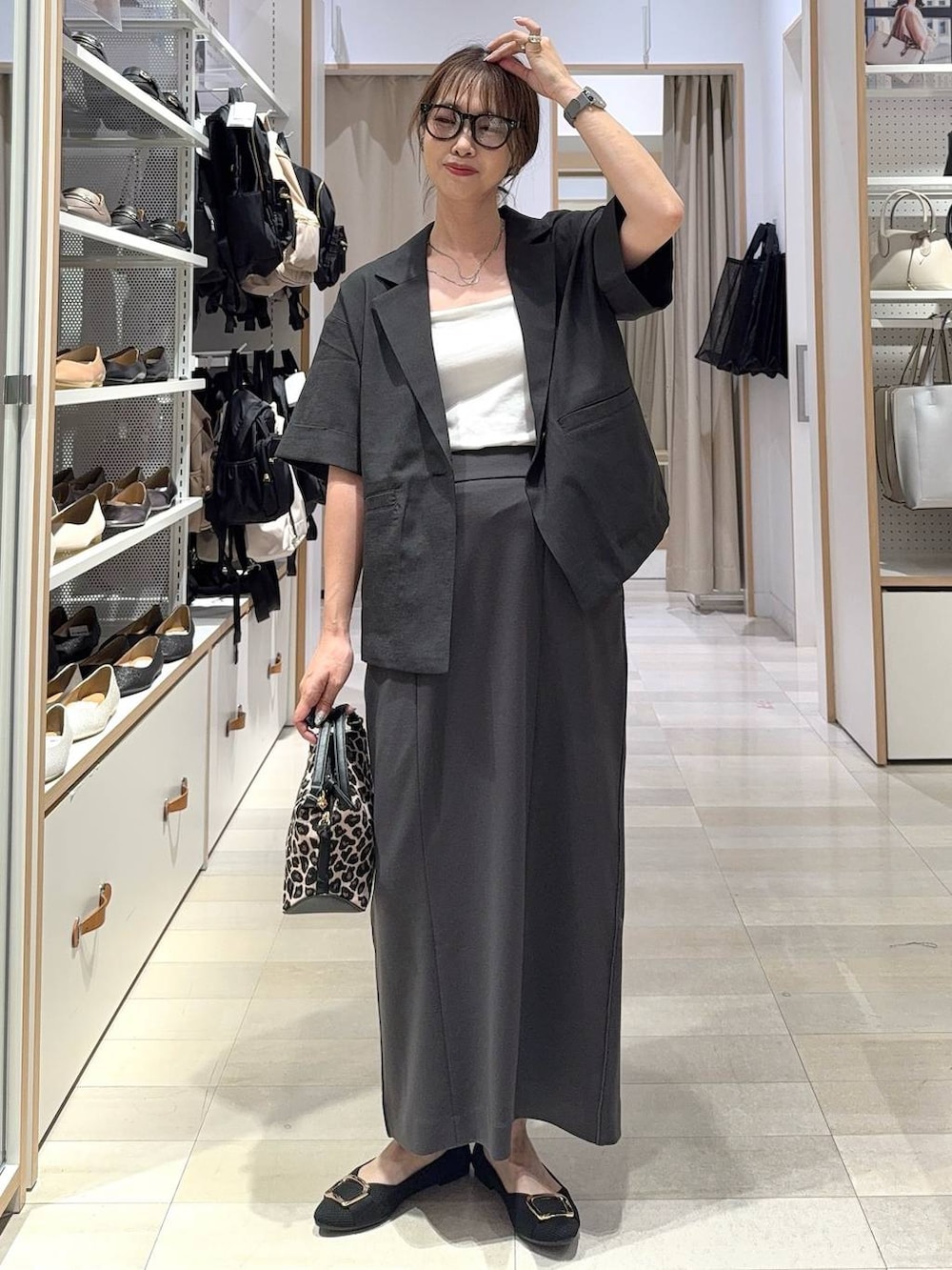 ホワイト系のショルダーバッグ、ブラック系のパンプス、ホワイト系のキャミソールを着用したレディースの夏コーディネートの4枚目の写真