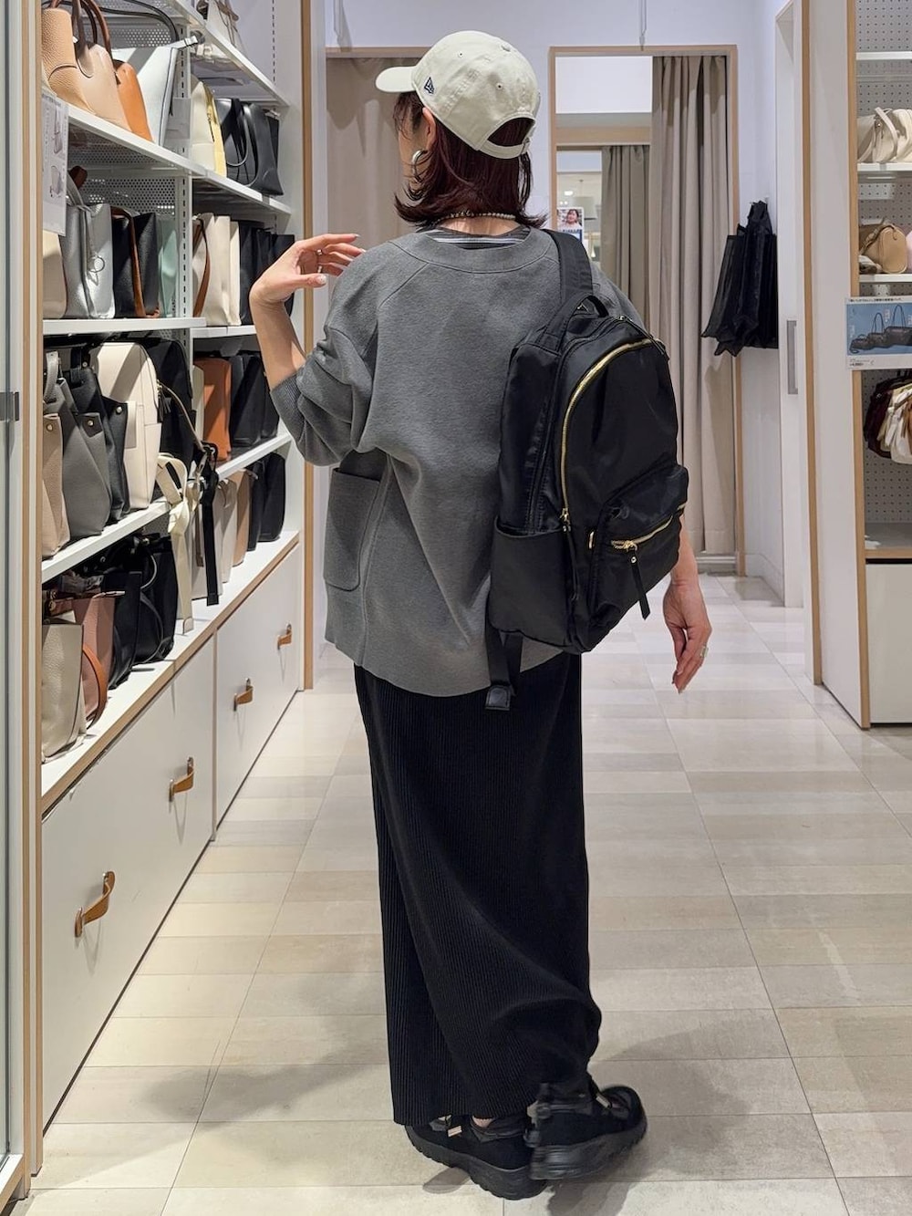 ブラック系のバックパック/リュック、グレー系のカーディガン/ボレロ、ブラウン系のタンクトップを着用したレディースの春コーディネートの3枚目の写真