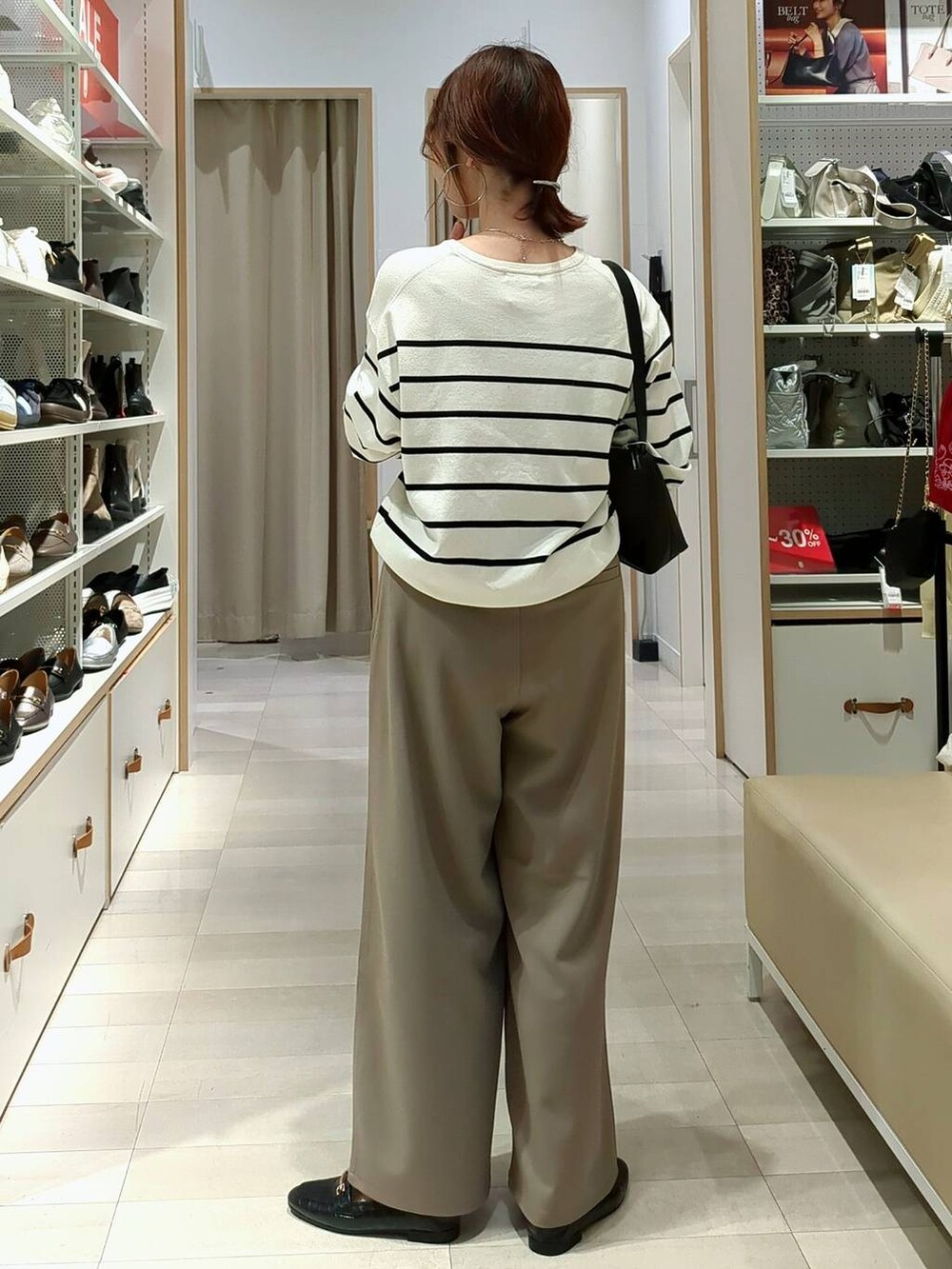 ブラック系のローファー、ブラック系のショルダーバッグ、ホワイト系のニット/セーターを着用したレディースの春コーディネートの4枚目の写真