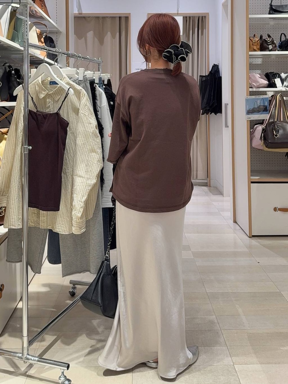 ブラック系のTシャツ/カットソー、グレー系のスカート、ブラウン系のスウェットを着用したレディースの春コーディネートの6枚目の写真