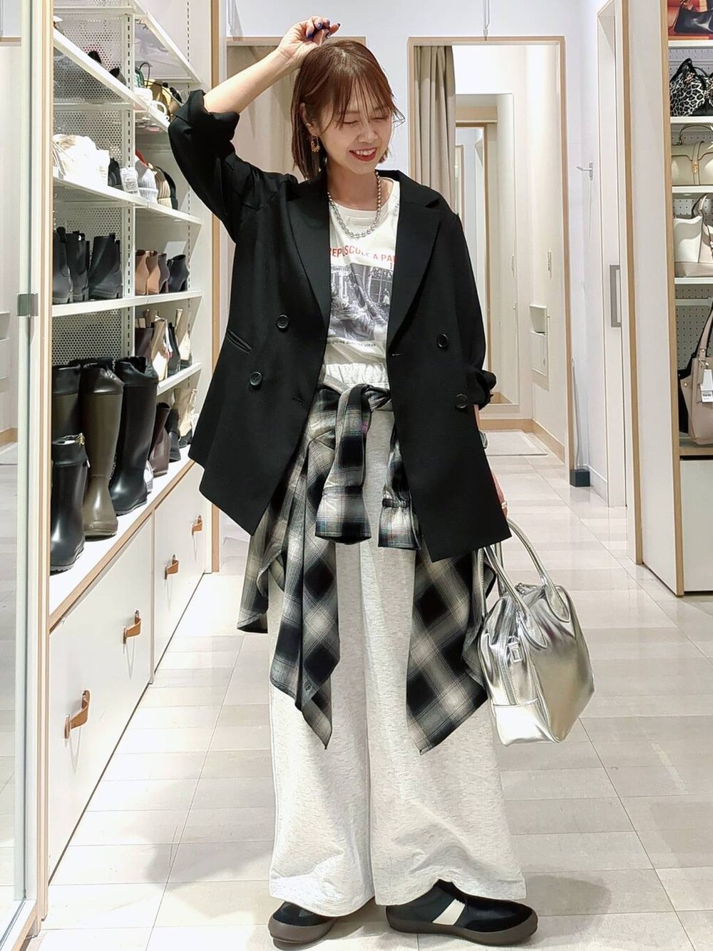 シルバー系のトートバッグ、ベージュ系のニット/セーター、ブラック系のその他パンツを着用したレディースの春コーディネートの3枚目の写真