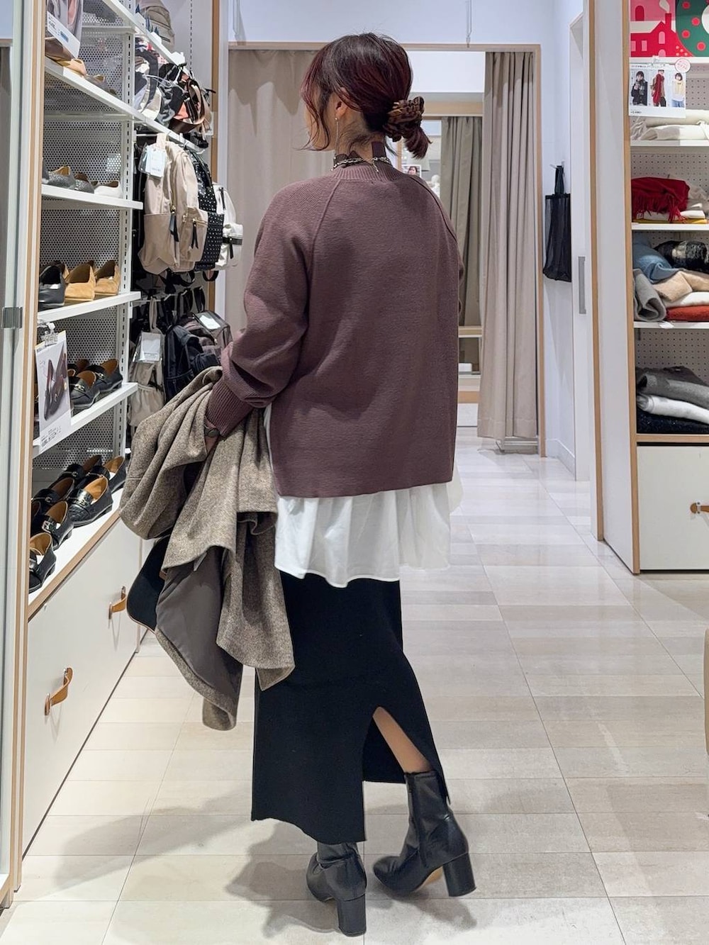 ブラウン系のチェスターコート、ホワイト系のTシャツ/カットソー、ブラウン系のニット/セーターを着用したレディースの冬コーディネートの8枚目の写真