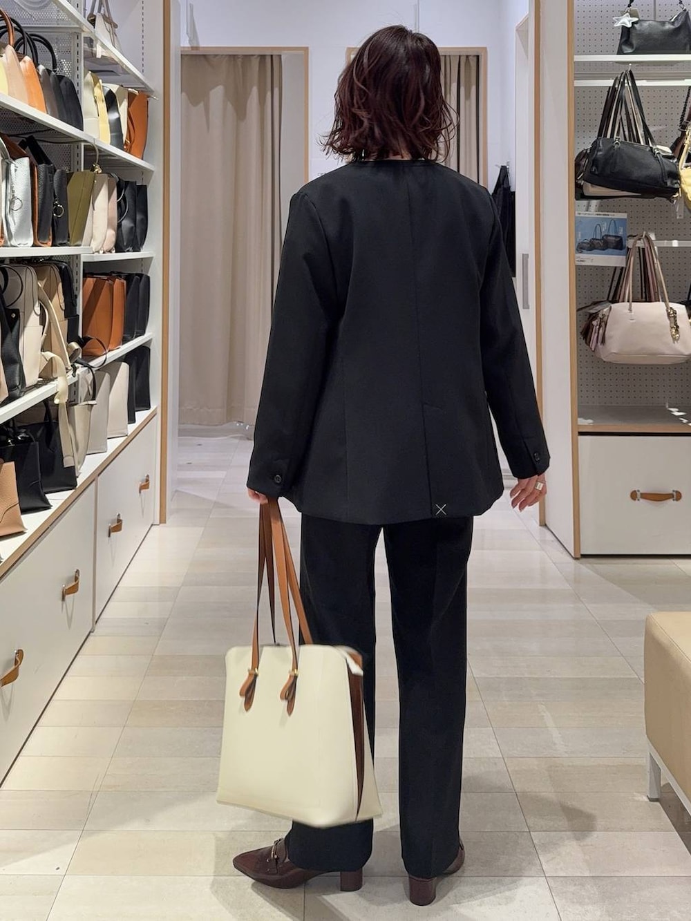 ブラック系のその他パンツ、ブラック系のテーラードジャケット、ホワイト系のトートバッグを着用したレディースの春コーディネートの6枚目の写真